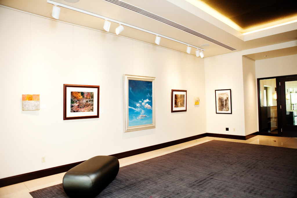 art gallery with painting of blue sky with cloud at center