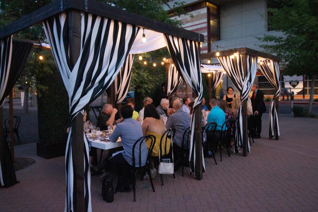 group at plated and staged event under outdoor canopy